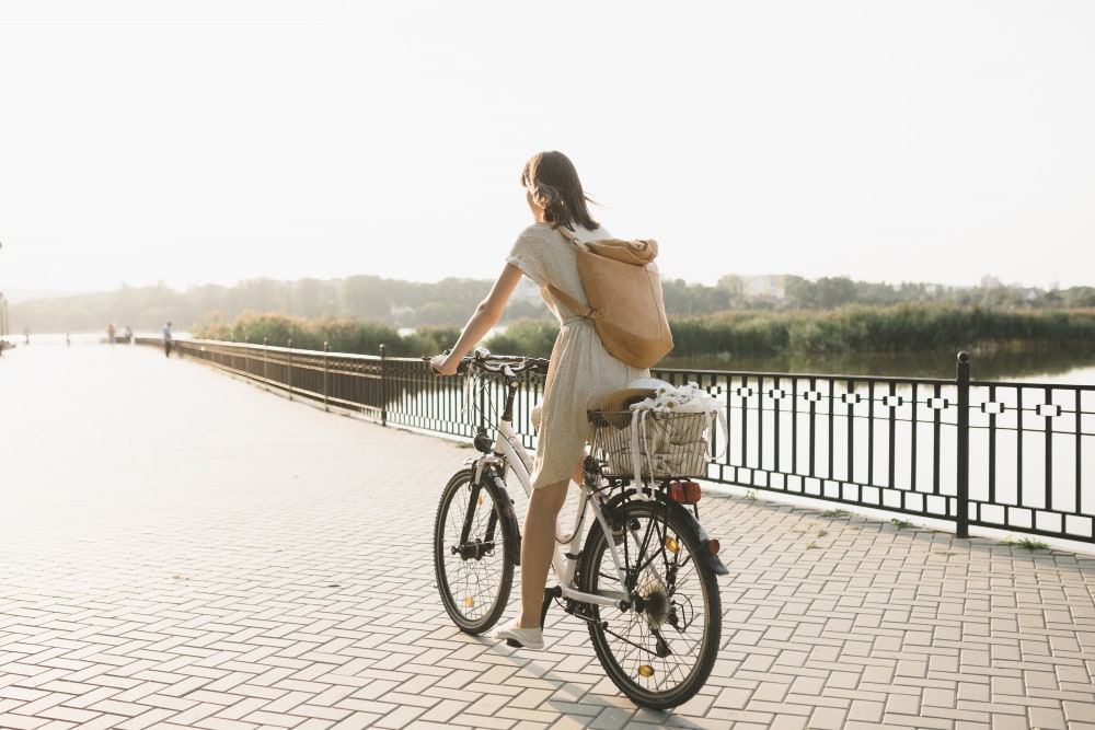 jeune femme sur un vélo sur un pont